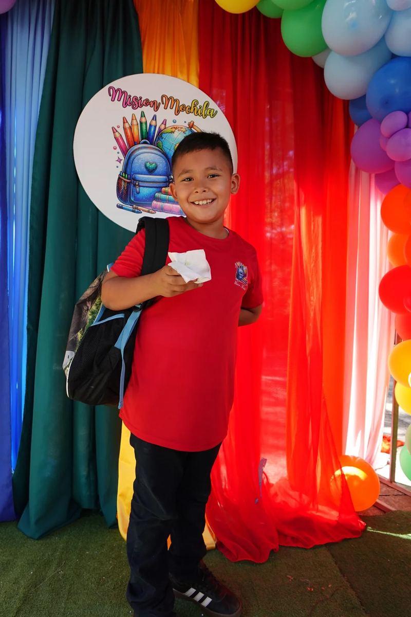 A boy shows off his new backpack