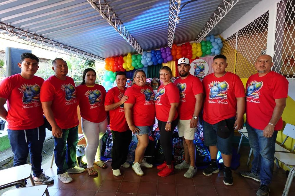 The full volunteer team lined up in front of the backpacks
