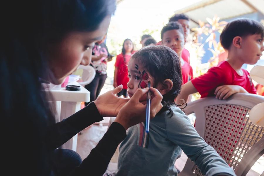 A volunteer paints a child's face at the celebration