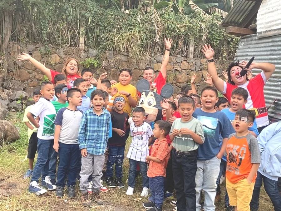 A group of schoolchildren cheering outdoors with Rosie