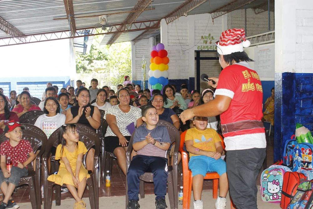 Kids and families gathered around a volunteer in a Santa hat
